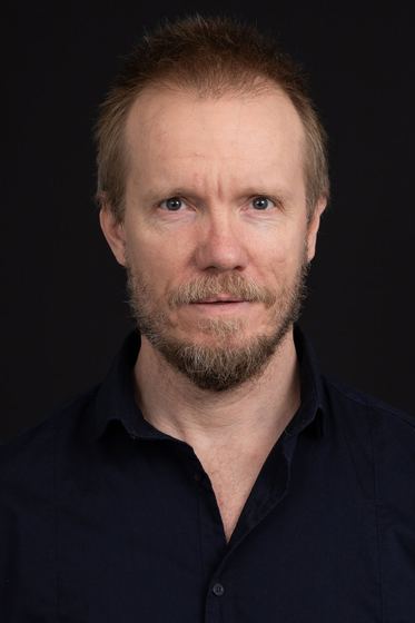 Matti Boustedt, straight-on studio portrait in navy shirt